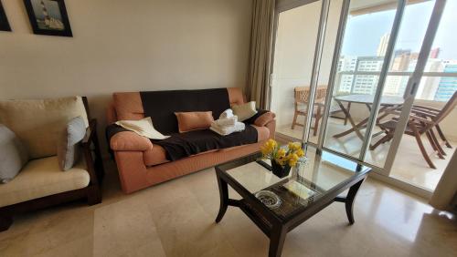 a living room with a couch and a table at Gemelos 22-Fincas Benidorm in Benidorm
