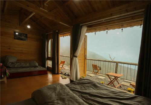 Habitación con cama y balcón con vistas. en MOONG Homestay & Coffee Tà Xùa en Bắc Yên