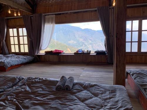 1 dormitorio con 1 cama y vistas a la montaña en MOONG Homestay & Coffee Tà Xùa, en Bắc Yên