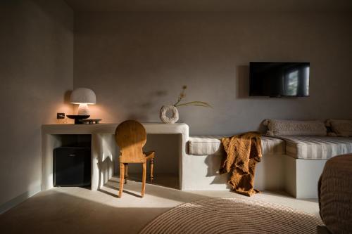a bedroom with a bed and a chair and a table at Euforia Retreat and Spa in Eforie Nord