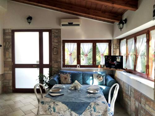 - un salon avec une table et un canapé bleu dans l'établissement La Casetta - Ascea (SA), à Ascea