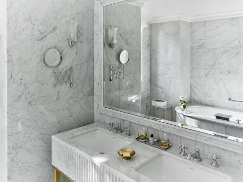 a bathroom with a sink and a mirror and a tub at The Dorchester - Dorchester Collection in London