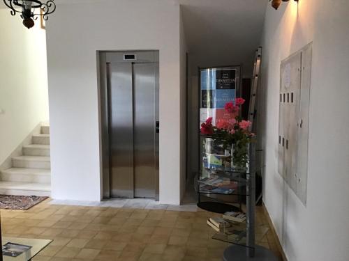 a hallway with a door and a vase of flowers at Villa Dinastija in Kali