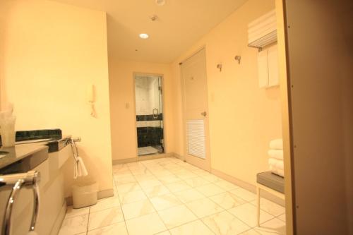 a bathroom with a shower and a sink with towels at Sendai Hills Hotel in Sendai