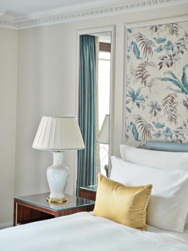 a bedroom with a bed and a table with a lamp at The Dorchester - Dorchester Collection in London
