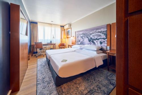 um quarto de hotel com uma cama e uma secretária em Arthotel Ana im Olympiapark em Munique