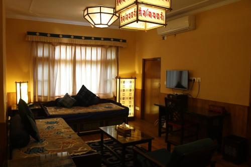 a living room with a couch and a tv at Chonor House in McLeod Ganj