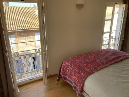 a bedroom with a bed and an open window at Appartement lumineux, terrasse, centre historique in Arles