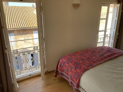 - une chambre avec un lit et une fenêtre ouverte dans l'établissement Appartement lumineux, terrasse, centre historique, à Arles