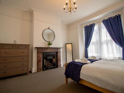 a bedroom with a bed and a mirror and a fireplace at Pass the Keys Cosy flat close to metro City and hospitals in Gosforth