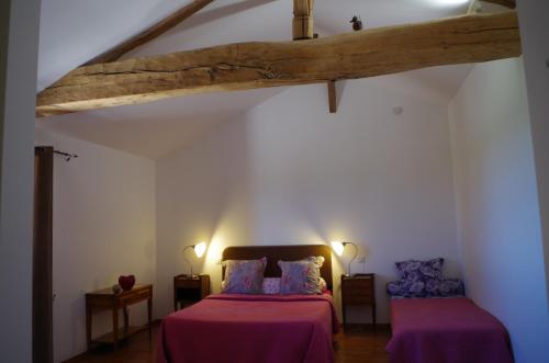 a bedroom with two beds with purple sheets at Domaine Joseph LAFARGE Wine Resort B&B in Lugny