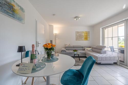 a living room with a table and chairs and a couch at fewo1846 - Strandresidenz Wassersleben Meeresbrise App 685 - komfortables Apartment mit Balkon und Meerblick in Harrislee