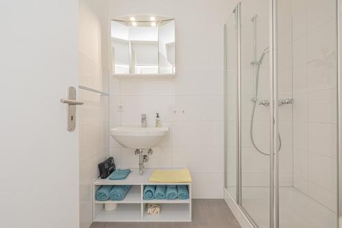a white bathroom with a sink and a shower at fewo1846 - Strandresidenz Wassersleben Meeresbrise App 685 - komfortables Apartment mit Balkon und Meerblick in Harrislee