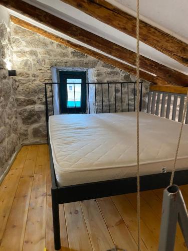 a rope bed in a room with a window at Apartman Lepetane in Tivat