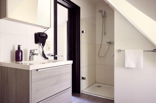 a bathroom with a sink and a shower at Van der Valk Naturresort Drewitz in Nossentiner Hütte