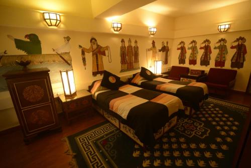 a bedroom with two beds and a living room with at Chonor House in McLeod Ganj