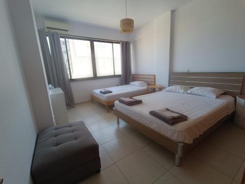 ein Schlafzimmer mit 2 Betten und einem Stuhl darin in der Unterkunft Heart of the City in Limassol