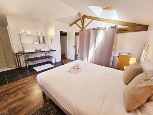 um quarto com uma cama branca e uma cozinha em Gîte avec piscine Chez Labaurie em Marthon