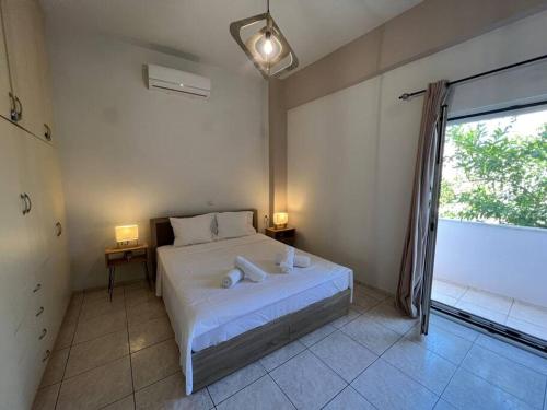 a bedroom with a bed and a large window at Minimalist Flat with Balcony in Heraklio Town