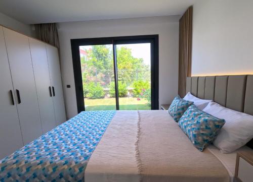 a bedroom with a large bed with a large window at Galimera in Bodrum City