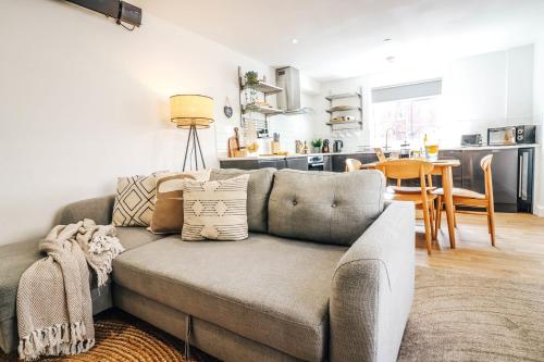 a living room with a couch and a kitchen at Principality View Apartment One, by Solace Stays in Cardiff