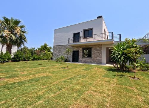 a house with a large yard in front of it at Galimera in Bodrum City