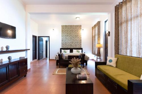 a living room with a couch and a table at Poetry by the Hills - House Of Hive, Ramgarh, Mukteshwar, Nainital in Rāmgarh