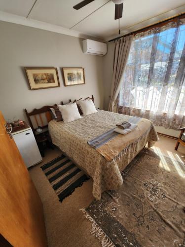 a bedroom with a bed and a large window at Emani Guest House in Mokopane