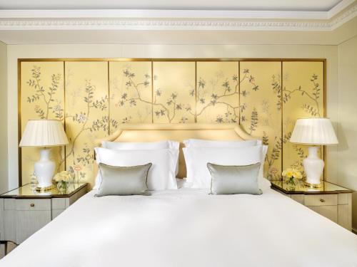 una camera da letto con un grande letto bianco con due lampade di The Dorchester - Dorchester Collection a Londra