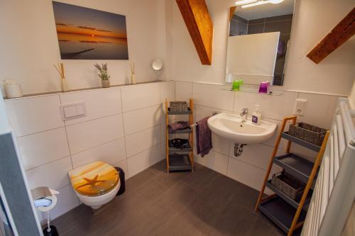 y baño con lavabo y aseo. en Grashaus Leevke, en Krummhörn