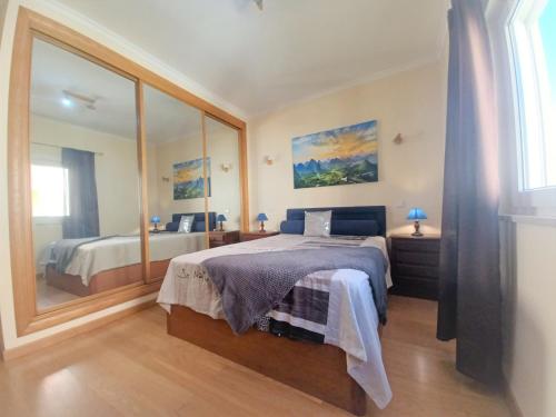 um quarto com uma cama e um espelho grande em RIVER Beach Apartment em Portimão