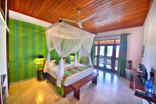 a bedroom with a bed with a canopy at Rockside Beach Resort in Bentota