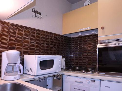 La cuisine est équipée d'un four micro-ondes et d'un évier. dans l'établissement Studio 6 pers, centre station, skis aux pieds, wifi - FR-1-322-26, aux Orres