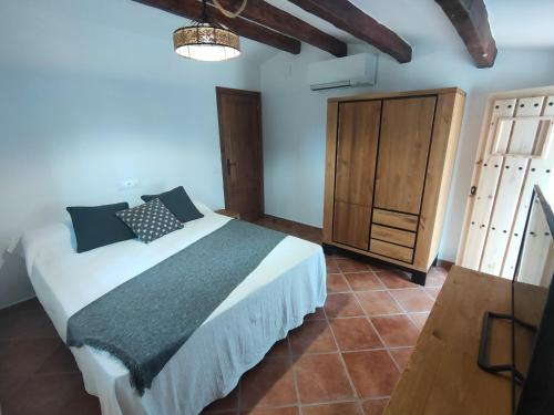 1 dormitorio con 1 cama y armario de madera en Casa Cuatro Vientos, en Tordera