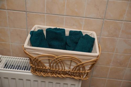 un panier rempli de serviettes vertes sur un radiateur dans l'établissement Carla House, à Vidolm