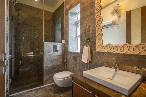 uma casa de banho com um lavatório e um chuveiro em Timeless Elegance by StayVista - Poolside Villa with Lawn & Terrace em Calcutá