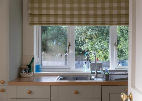 a kitchen with a sink and a window at Duart Cottage in Glencoe