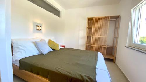 - une chambre avec un lit dans une pièce dotée d'une fenêtre dans l'établissement Lukenda Rooms - Apartment, à Pakoštane