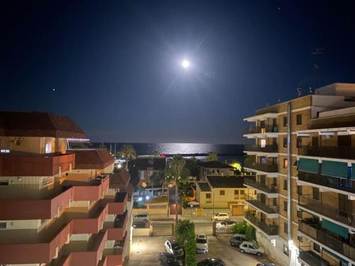 a view of a city at night with the moon at Brisa Marina in Las Canteras