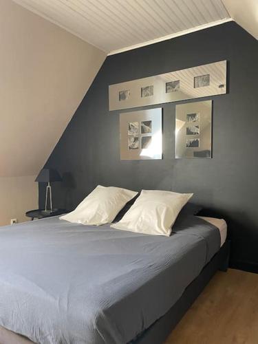 - une chambre dotée d'un lit avec des photos sur le mur dans l'établissement Le Clos des Bambous, à Saint-Martin-lez-Tatinghem