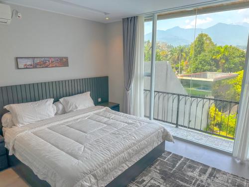 ein Schlafzimmer mit einem Bett und einem großen Fenster in der Unterkunft Armada Resort Puncak in Sampal 2