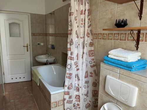 y baño con bañera, lavamanos y cortina de ducha. en Home in Krakow Silvio's Apartments, en Cracovia