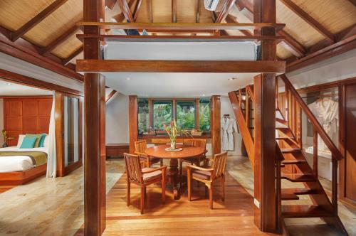 a dining room with a loft bed and a table and chairs at The Farm at San Benito in Lipa