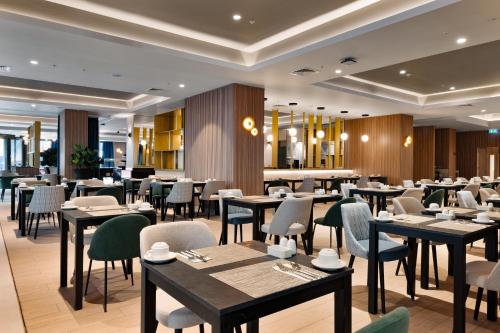 a restaurant with tables and chairs in a room at Riu Plaza London Victoria in London