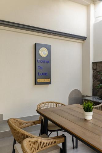 a dining room with a wooden table and chairs at Costa De Luxe Suites in Leptokaria