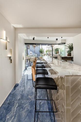 a bar with a row of bar stools at Costa De Luxe Suites in Leptokaria