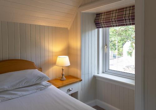 a bedroom with a bed and a window at Duart Cottage in Glencoe