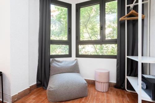 a living room with a couch and two windows at HOSTAL BEDMATES in Barcelona