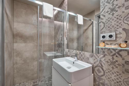 een badkamer met een witte wastafel en een douche bij Aparthotel Rimska 14 in Praag