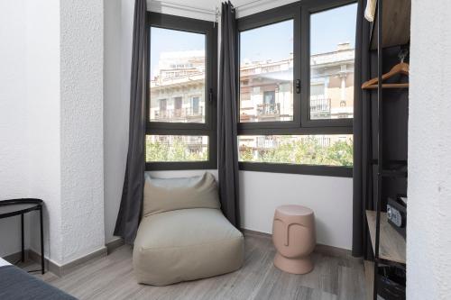 a room with a bean bag chair in front of two windows at HOSTAL BEDMATES in Barcelona